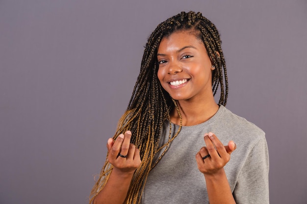 Joven mujer afro brasileña haciendo señas con sus manos ven ven aquí bienvenida