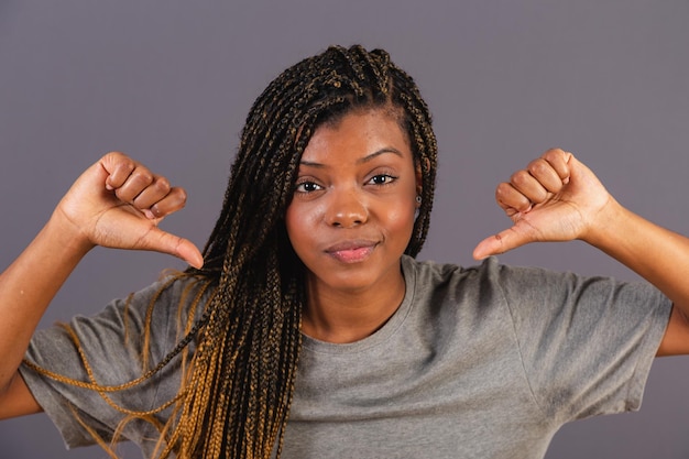 Joven mujer afro brasileña pulgar hacia abajo desaprobación mala aversión Negativo