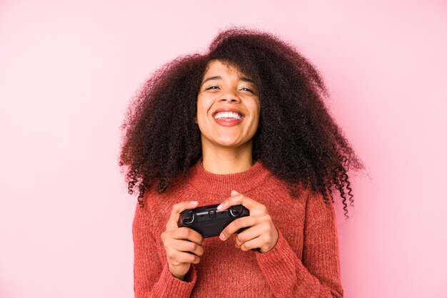 Joven mujer afro con un comando play aislado