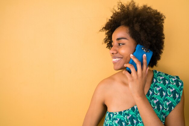 Joven mujer afro hablando por teléfono