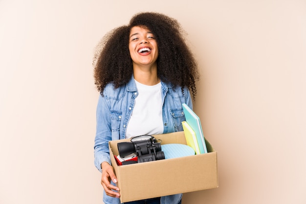 Joven mujer afro mudarse a casa Joven mujer afro riendo y divirtiéndose.