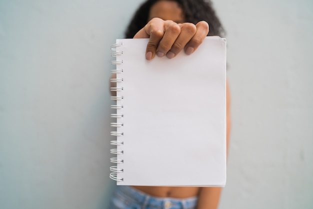 Joven mujer afro con papel en blanco.