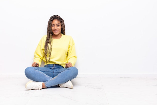 Joven mujer afro que parece feliz y tonta con una amplia, divertida y loca sonrisa aislada