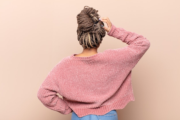 Foto joven mujer afro sintiéndose despistada y confundida, pensando en una solución