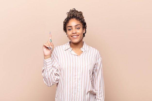 Joven mujer afro sonriendo alegre y felizmente