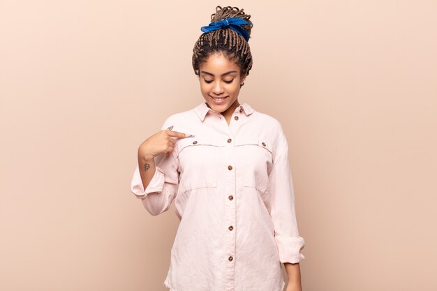 Joven mujer afro sonriendo alegremente y casualmente aislado