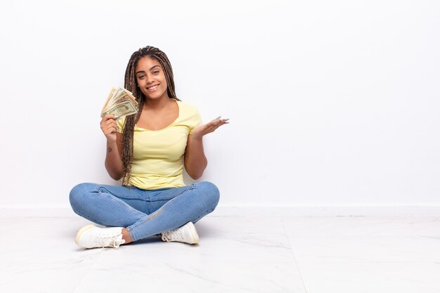 Joven mujer afro sonriendo alegremente, sintiéndose feliz