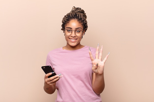 Joven mujer afro sonriendo y mirando amigable aislado