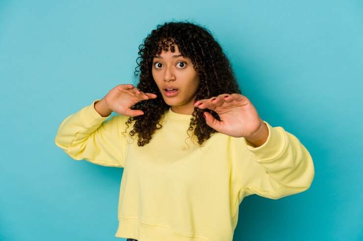Foto joven mujer afroamericana afro aislada está conmocionada debido a un peligro inminente