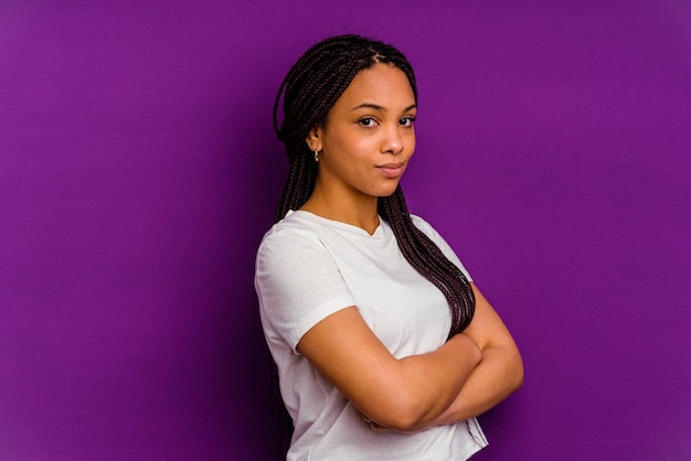 Joven mujer afroamericana aislada en la pared amarilla infeliz mirando al frente con expresión sarcástica