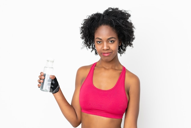 Joven mujer afroamericana aislada en la pared blanca con botella de agua deportiva