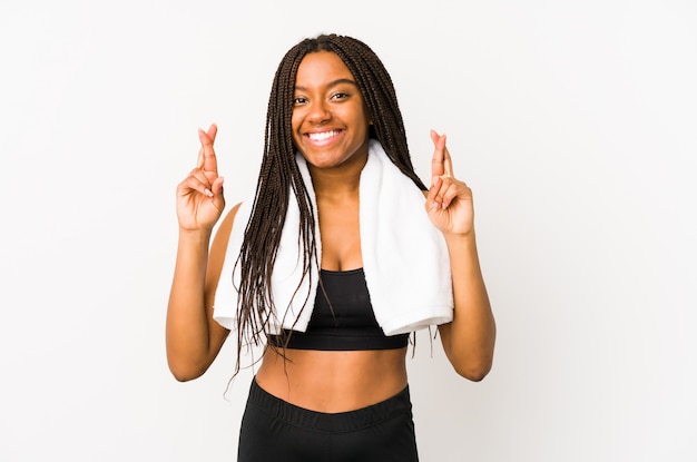 Joven mujer afroamericana deporte cruzando los dedos para tener suerte
