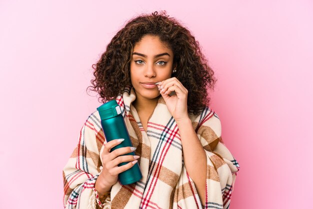 Joven mujer afroamericana descansando en un campamento aislado con los dedos en los labios manteniendo un secreto.