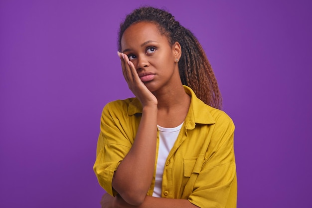 Joven mujer afroamericana frustrada hace soportes de palma de la cara en estudio púrpura