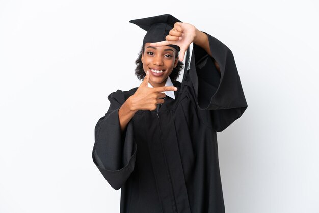 Joven mujer afroamericana graduada universitaria aislada sobre fondo blanco enfocando la cara Símbolo de encuadre