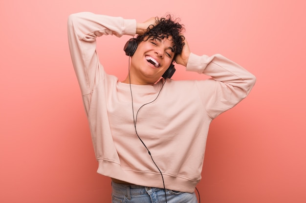 Foto joven mujer afroamericana con una marca de nacimiento bailando y escuchando música con auriculares