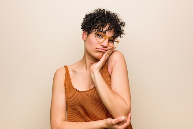 Foto joven mujer afroamericana con marca de nacimiento de la piel que está aburrida, fatigada y necesita un día de relajación.