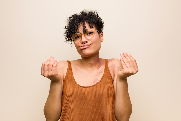 Joven mujer afroamericana con marca de nacimiento de piel que muestra que no tiene dinero.