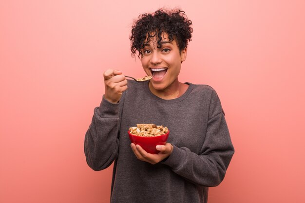 Joven mujer afroamericana con una marca de nacimiento con un tazón de cereal