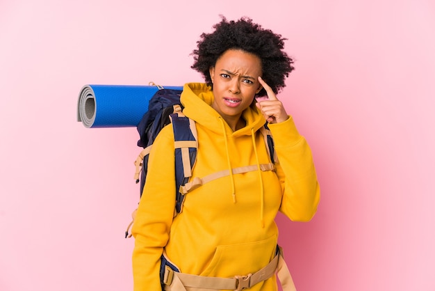 Joven mujer afroamericana mochilero aislada mostrando un gesto de decepción con el dedo índice.