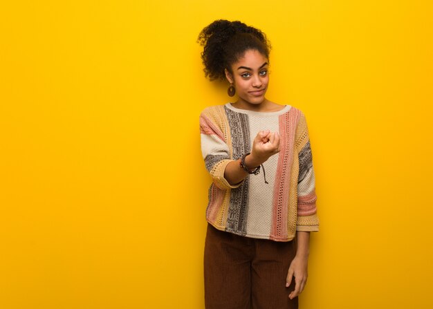 Joven mujer afroamericana negra con ojos azules invitando a venir