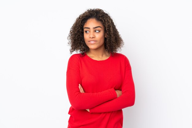 Joven mujer afroamericana en la pared mirando hacia el lado