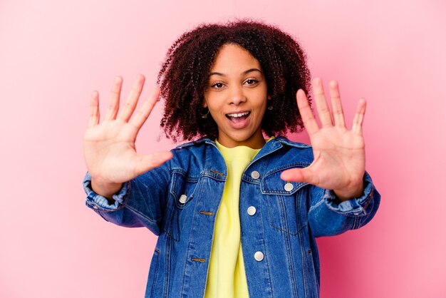 Joven mujer afroamericana de raza mixta aislada mostrando el número diez con las manos.