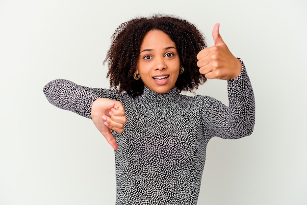 Joven mujer afroamericana de raza mixta aislada mostrando los pulgares hacia arriba y hacia abajo, difícil elegir el concepto