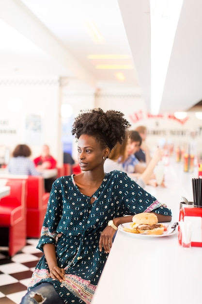 Joven mujer afroamericana en el restaurante