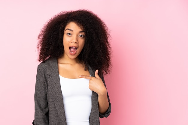 Joven mujer afroamericana sobre pared aislada con expresión facial sorpresa