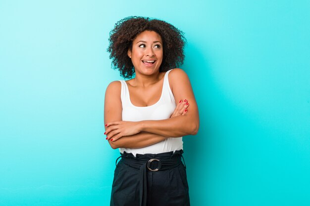 Joven mujer afroamericana sonriendo confiados con los brazos cruzados.