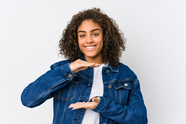 Joven mujer afroamericana sosteniendo algo con ambas manos, presentación del producto.