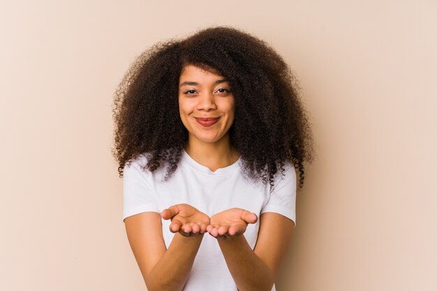 Joven mujer afroamericana sosteniendo algo con palmeras