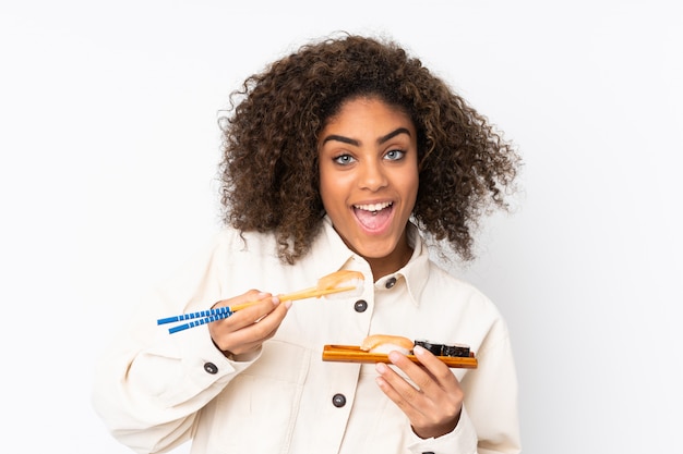 Joven mujer afroamericana con sushi aislado en blanco