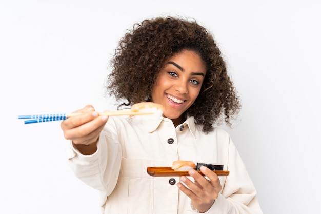 Joven mujer afroamericana con sushi aislado en blanco