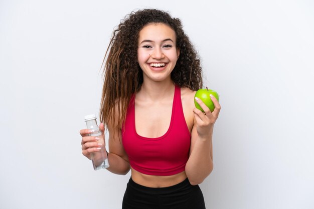 Joven mujer árabe aislada de fondo blanco con una manzana y una botella de agua