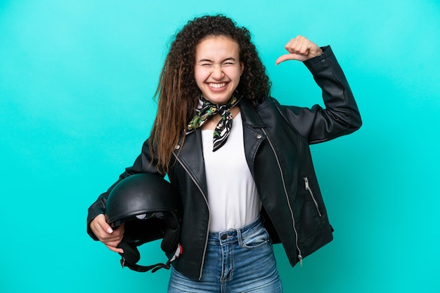 Foto joven mujer árabe con un casco de motocicleta aislado de fondo azul haciendo un gesto fuerte