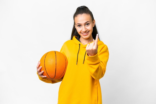 Joven mujer árabe jugando baloncesto sobre fondo blanco aislado haciendo gesto de venir