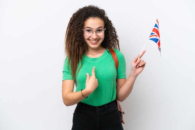 Joven mujer árabe sosteniendo una bandera del Reino Unido aislada de fondo blanco con una expresión facial sorpresa