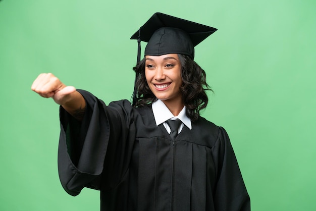 Joven mujer argentina graduada de la universidad sobre un fondo aislado dando un gesto de pulgar hacia arriba