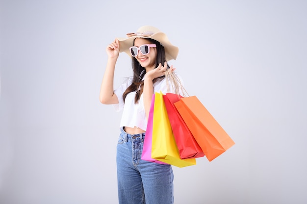 Joven mujer asiática con bolsas de compras y sombrero de paja