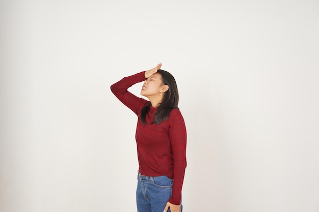 Foto joven mujer asiática con camiseta roja mano sobre la cabeza olvidar algo gesto aislado sobre fondo blanco