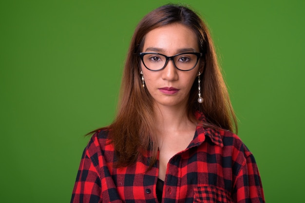 Joven mujer asiática delgada sobre fondo verde