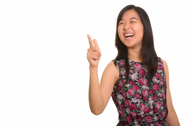 Joven mujer asiática feliz riendo mientras señala con el dedo aislado