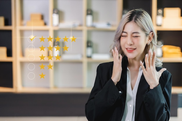 Joven mujer asiática feliz tasa de revisión de comentarios icono de cinco estrellas para el servicio al cliente en el concepto de marketing empresarial de la experiencia de la aplicación móvil