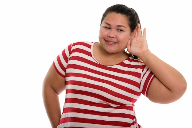 Joven mujer asiática gorda feliz sonriendo y escuchando