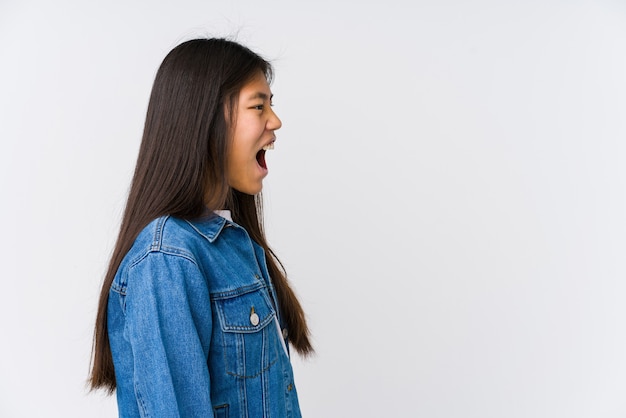 Joven mujer asiática gritando hacia un espacio de copia