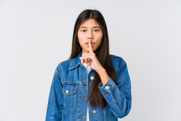 Joven mujer asiática guardando un secreto o pidiendo silencio