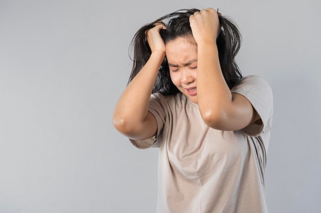 Joven mujer asiática hermosa mano tocando la cabeza se siente deprimida estrés dolor de cabeza