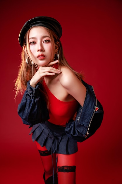 Joven mujer asiática de moda en rojo con chaqueta de denim y boina